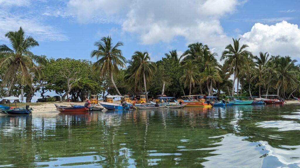 Pirogues et bateaux colorés se reflétant dans les eaux calmes du lagon de Sainte-Marie